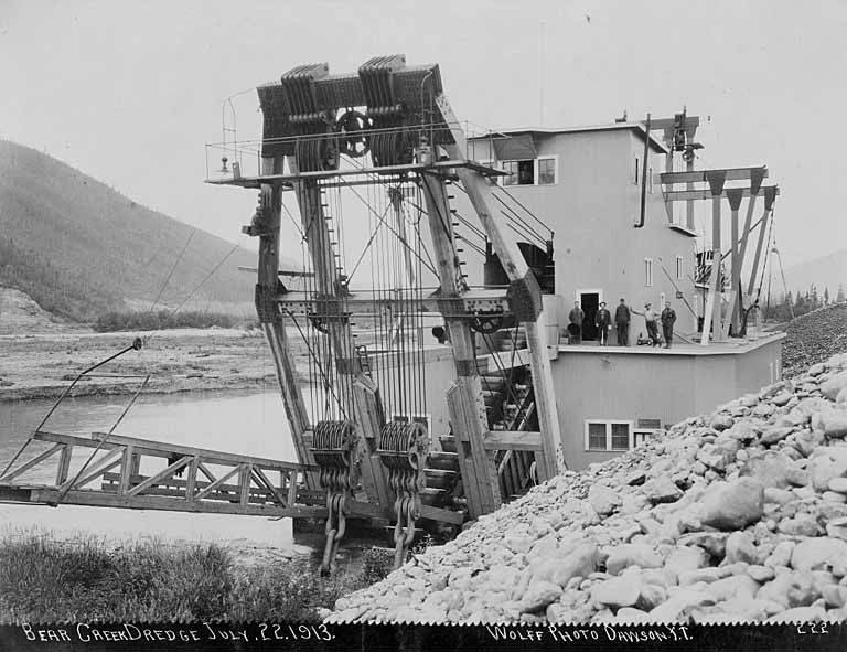 hommes debout sur l'extraction de l'or drague dans bear creek klondike river valley yukon
